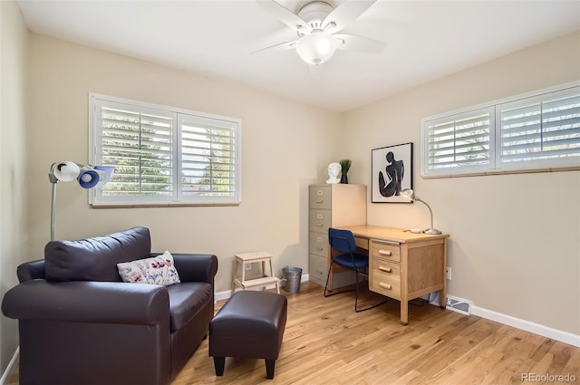 sitting room with healthy amount of natural light, light wood finished floors, ceiling fan, and baseboards