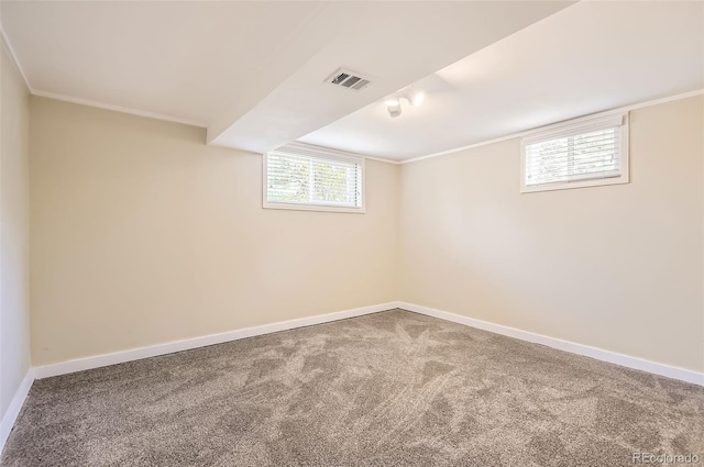 below grade area with carpet flooring, baseboards, healthy amount of natural light, and ornamental molding