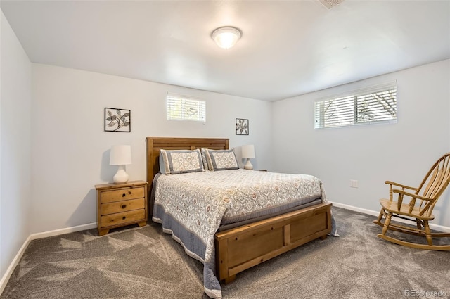 bedroom with dark carpet and baseboards