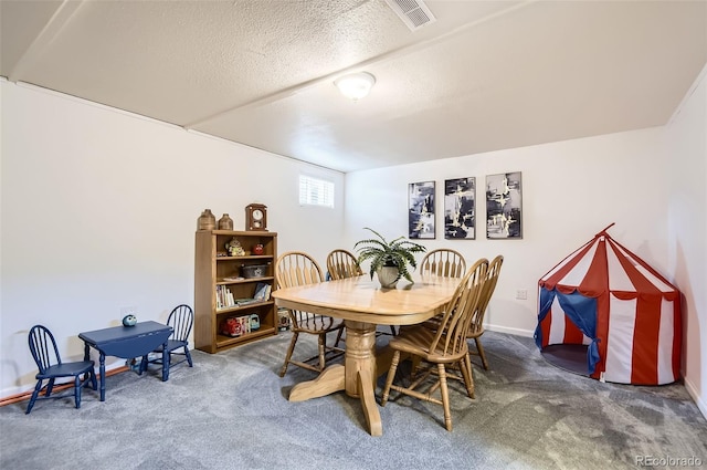 dining room with carpet flooring, a textured ceiling, and baseboards