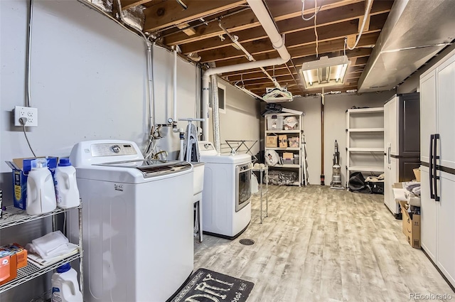 clothes washing area featuring independent washer and dryer and light wood-type flooring