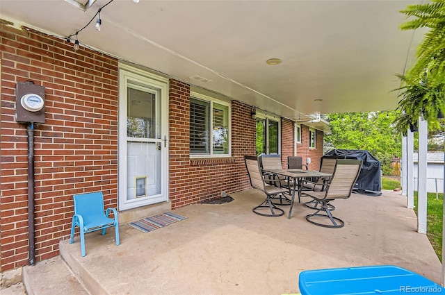 view of patio featuring outdoor dining space, fence, and grilling area