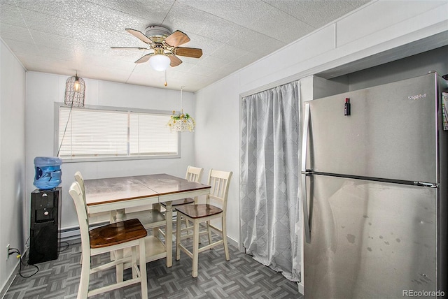 dining area with ceiling fan and dark parquet flooring