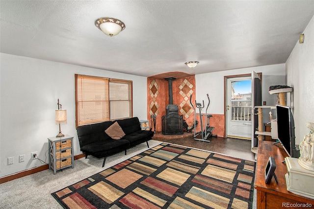 carpeted living room with a textured ceiling and a wood stove