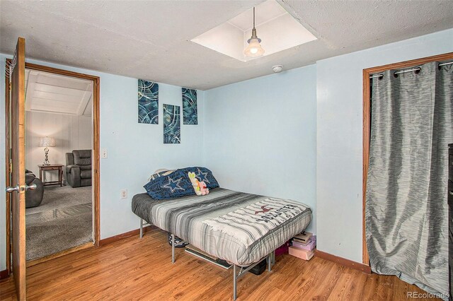 bedroom with a textured ceiling and light wood-type flooring