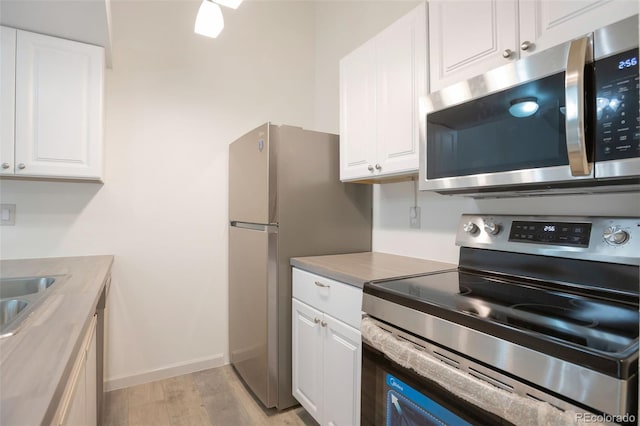 4283 S Salida Way Unit 12, Aurora, CO 80013 - kitchen with stainless steel appliances, white cabinetry, and light wood-style floors