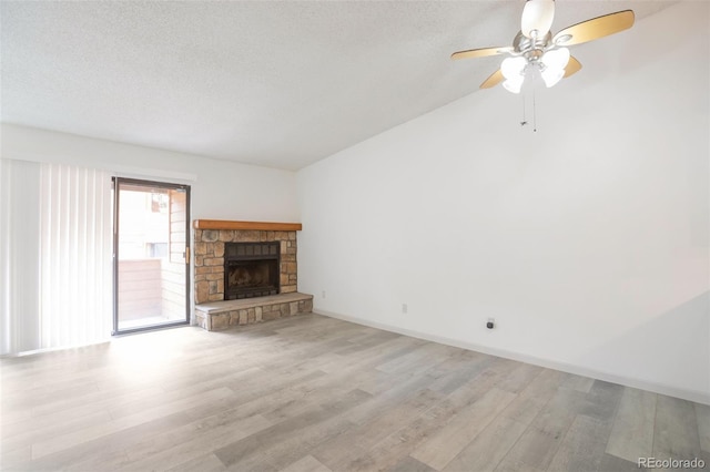 4283 S Salida Way Unit 12, Aurora, CO 80013 - unfurnished living room featuring light wood-style floors, a ceiling fan, a textured ceiling, a fireplace, and lofted ceiling