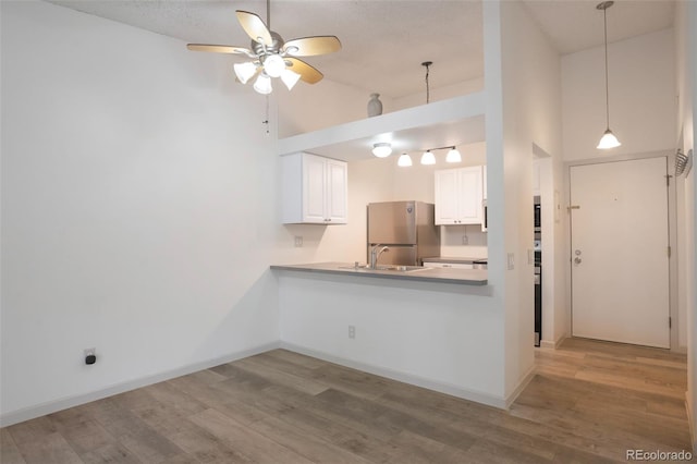 4283 S Salida Way Unit 12, Aurora, CO 80013 - kitchen featuring freestanding refrigerator, a ceiling fan, high vaulted ceiling, light wood-type flooring, and white cabinets
