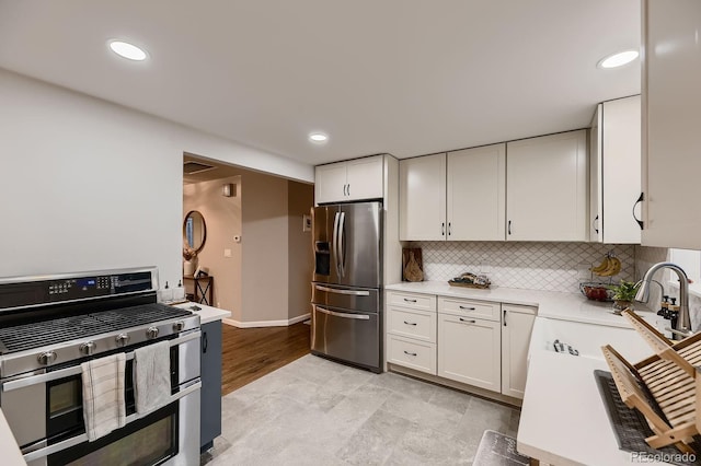 1100 E Harvey St, Castle Rock, CO 80108 - kitchen featuring appliances with stainless steel finishes, light countertops, white cabinetry, tasteful backsplash, and recessed lighting