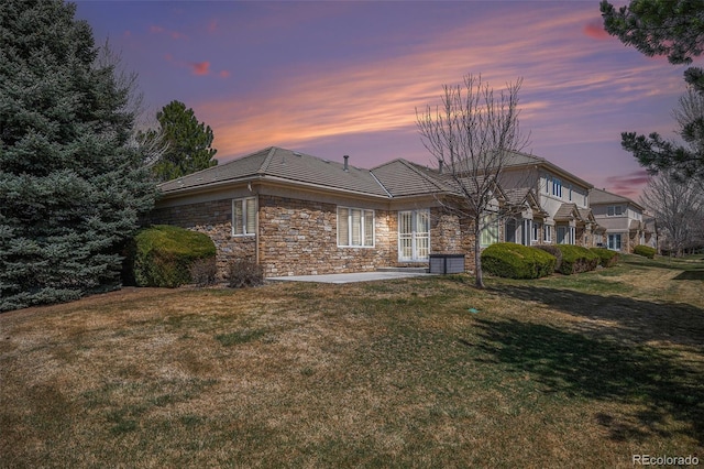 13806 E Chenango Dr, Aurora, CO 80015 - back of house featuring a lawn, french doors, a patio, stone siding, and cooling unit