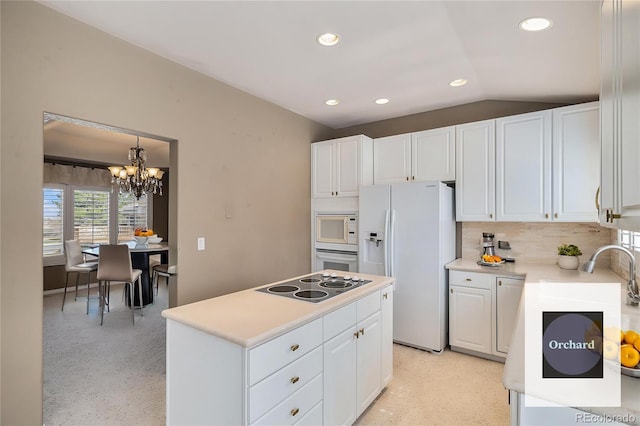 13806 E Chenango Dr, Aurora, CO 80015 - kitchen with white appliances, white cabinets, a chandelier, light countertops, and vaulted ceiling