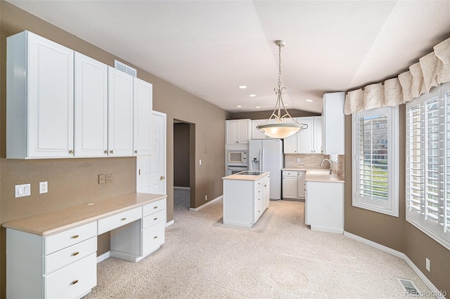 13806 E Chenango Dr, Aurora, CO 80015 - kitchen featuring white appliances, a center island, white cabinetry, light countertops, and a sink