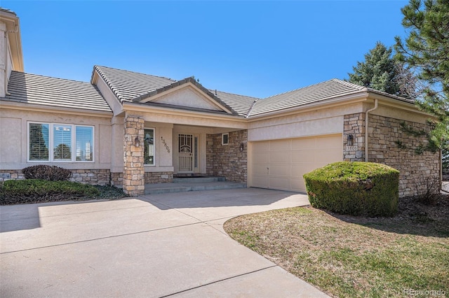 13806 E Chenango Dr, Aurora, CO 80015 - ranch-style house with stone siding, a tile roof, a garage, and concrete driveway