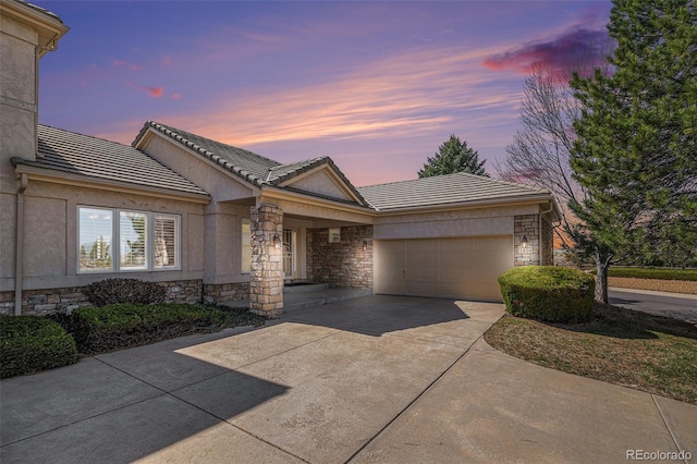 13806 E Chenango Dr, Aurora, CO 80015 - ranch-style house featuring stone siding, a tile roof, a garage, driveway, and stucco siding