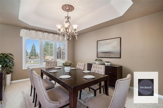 13806 E Chenango Dr, Aurora, CO 80015 - dining area featuring a chandelier, a tray ceiling, and light carpet