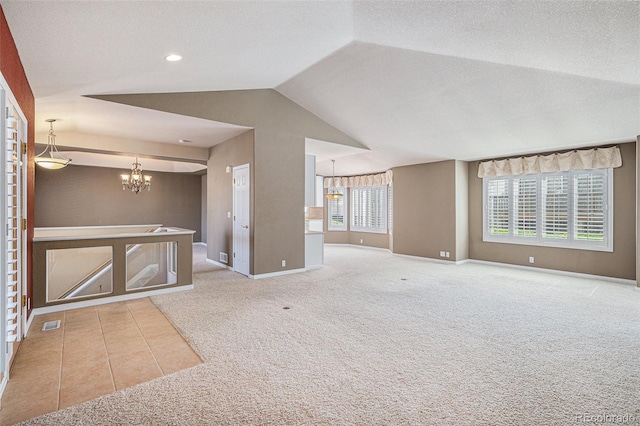 13806 E Chenango Dr, Aurora, CO 80015 - unfurnished living room featuring carpet floors, a chandelier, vaulted ceiling, and tile patterned floors