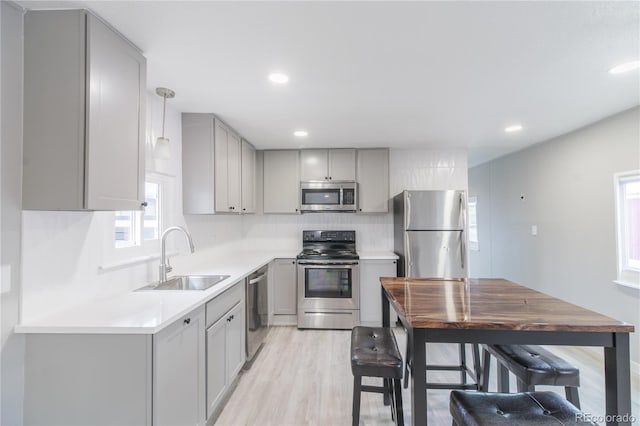 14701 E Colfax Ave Unit A5, Aurora, CO 80011 - kitchen featuring appliances with stainless steel finishes, gray cabinets, a sink, light wood-type flooring, and light countertops