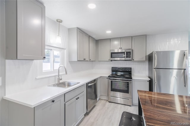 14701 E Colfax Ave Unit A5, Aurora, CO 80011 - kitchen featuring appliances with stainless steel finishes, a sink, gray cabinets, wood counters, and light wood-style floors