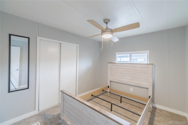 14701 E Colfax Ave Unit A5, Aurora, CO 80011 - unfurnished bedroom featuring light carpet, a closet, baseboards, and a textured ceiling