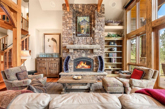 living area with a towering ceiling, a fireplace, and hardwood / wood-style floors