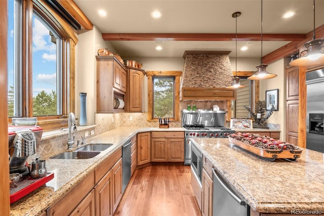 kitchen with sink, custom range hood, decorative backsplash, and light stone countertops