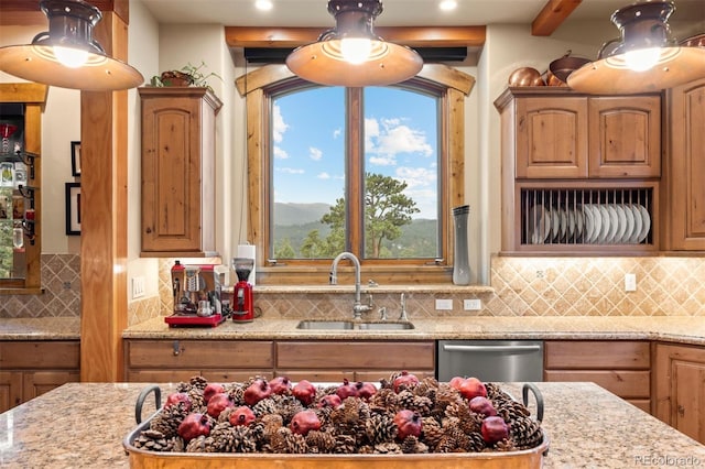 kitchen featuring sink, dishwasher, light stone counters, and tasteful backsplash