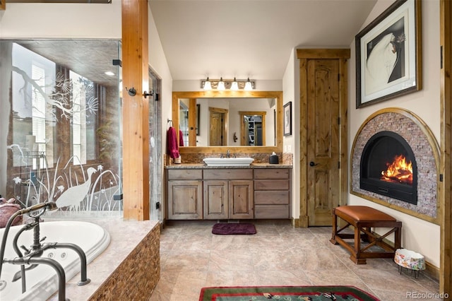 bathroom with lofted ceiling, vanity, and a relaxing tiled tub