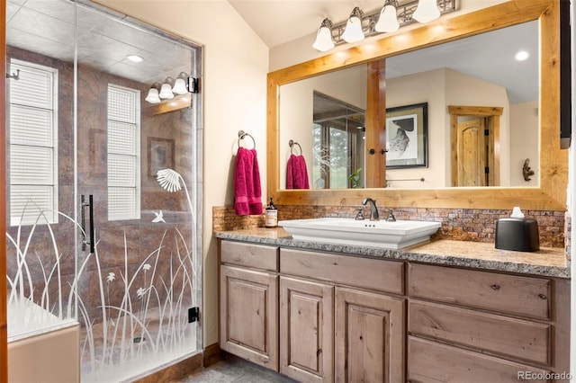 bathroom featuring lofted ceiling, vanity, and backsplash