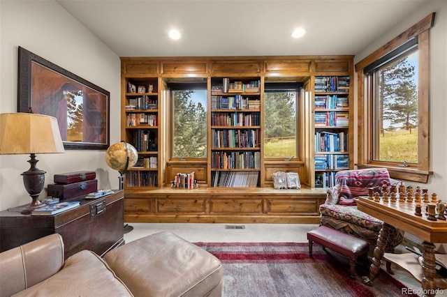 sitting room with carpet and built in shelves