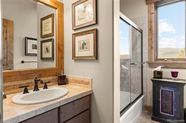 bathroom with vanity and combined bath / shower with glass door