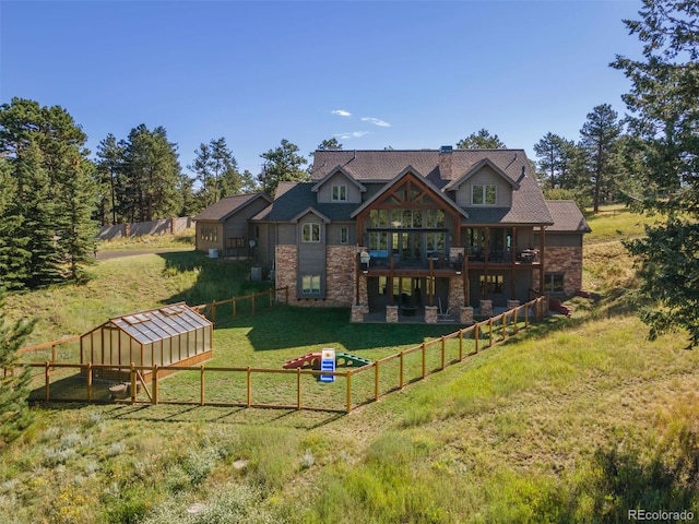 back of house with a yard and an outdoor structure