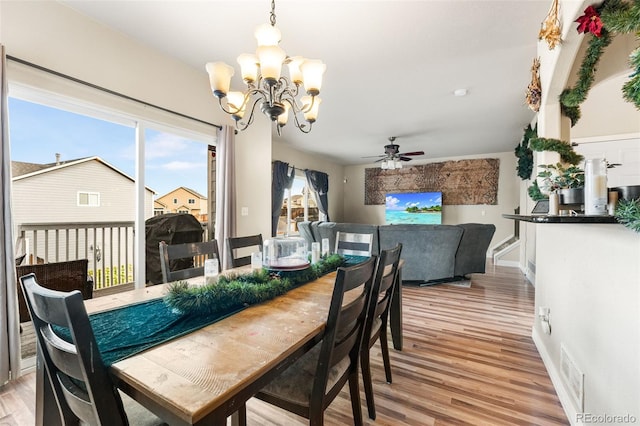 dining space with light wood-type flooring and ceiling fan with notable chandelier