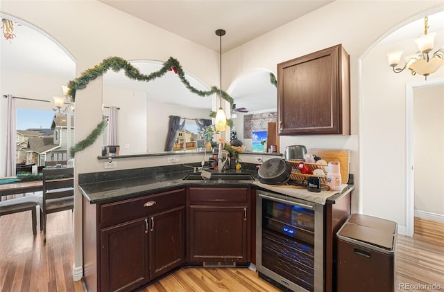 kitchen featuring pendant lighting, light hardwood / wood-style floors, wine cooler, and a wealth of natural light