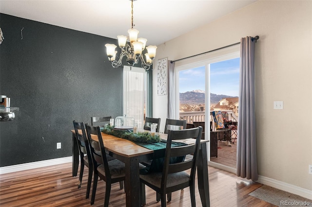 dining room featuring a mountain view, hardwood / wood-style flooring, and an inviting chandelier