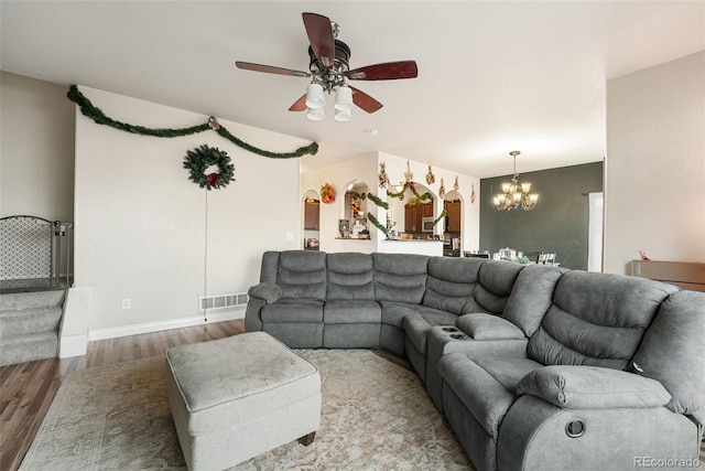 living room featuring hardwood / wood-style floors and ceiling fan with notable chandelier