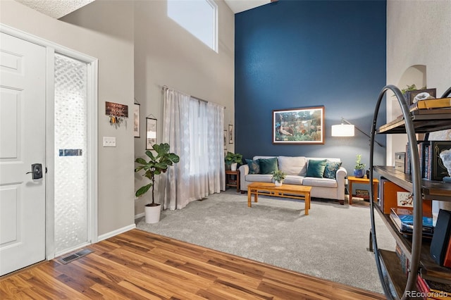 interior space with a towering ceiling and hardwood / wood-style floors