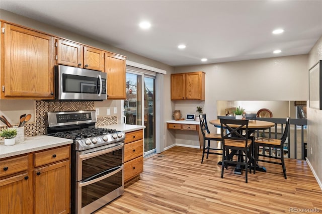 kitchen featuring backsplash, light hardwood / wood-style flooring, and stainless steel appliances