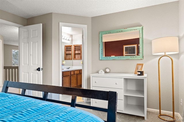 bedroom with ensuite bathroom, sink, light carpet, and a textured ceiling