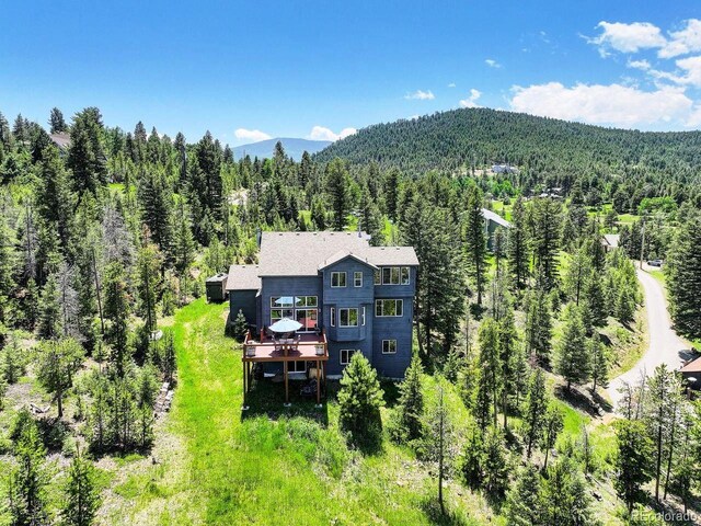 30889 Manitoba Dr, Evergreen, CO 80439 - view from above of property with a heavily wooded area and mountains