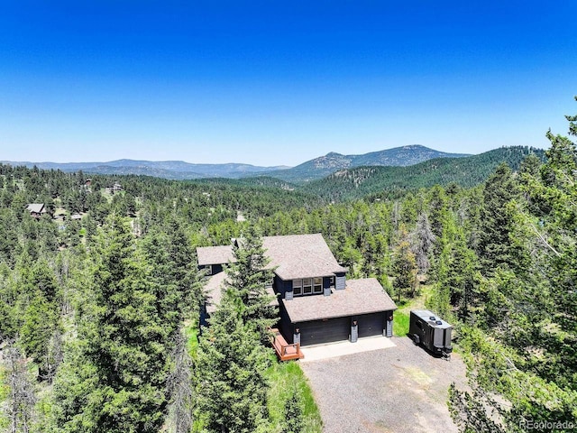 30889 Manitoba Dr, Evergreen, CO 80439 - view from above of property featuring a heavily wooded area and a mountainous background