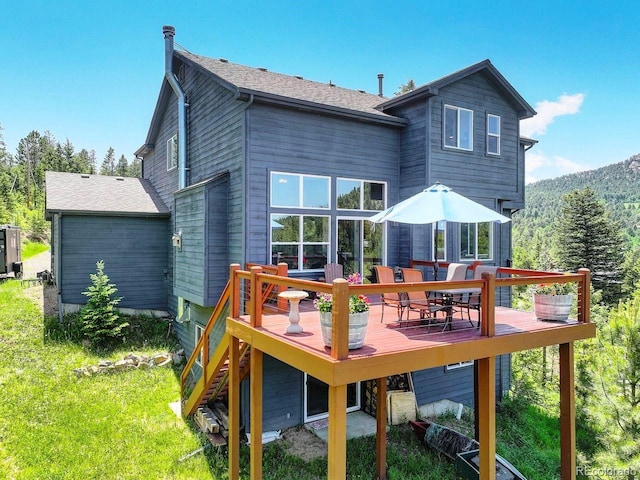 30889 Manitoba Dr, Evergreen, CO 80439 - back of property with a deck and outdoor dining area