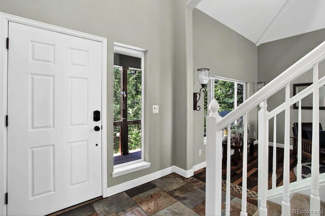 30889 Manitoba Dr, Evergreen, CO 80439 - foyer entrance with stone tile floors, healthy amount of natural light, stairway, and high vaulted ceiling