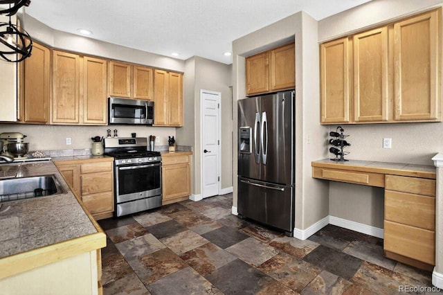 30889 Manitoba Dr, Evergreen, CO 80439 - kitchen with appliances with stainless steel finishes, built in desk, stone tile floors, and recessed lighting