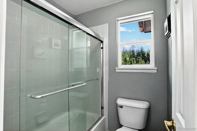 30889 Manitoba Dr, Evergreen, CO 80439 - bathroom with a textured wall and bath / shower combo with glass door