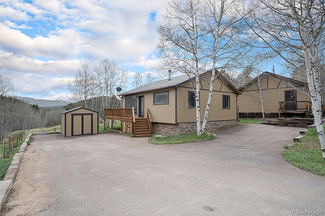 70 Silver Springs Rd, Bailey, CO 80421 - view of side of property featuring a storage unit, an outbuilding, metal roof, stairs, and a deck
