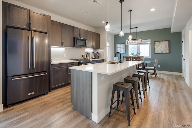 4184 Kalamath St, Denver, CO 80211 - kitchen with high end appliances, a sink, dark brown cabinetry, and recessed lighting