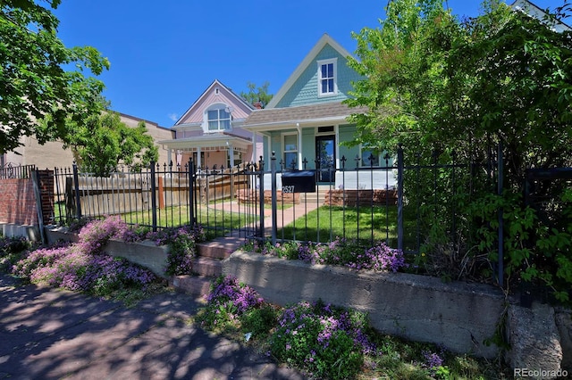2527 W Dunkeld Pl, Denver, CO 80211 - view of front of house featuring a porch and a fenced front yard