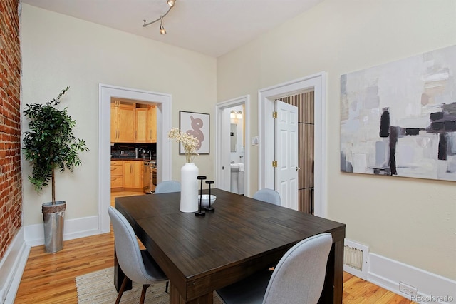 2527 W Dunkeld Pl, Denver, CO 80211 - dining space with light wood-style flooring and brick wall