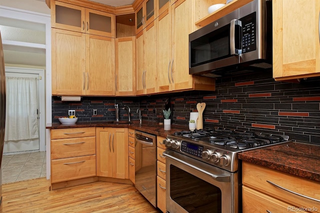 2527 W Dunkeld Pl, Denver, CO 80211 - kitchen featuring stainless steel appliances, decorative backsplash, light brown cabinets, glass insert cabinets, and dark stone counters