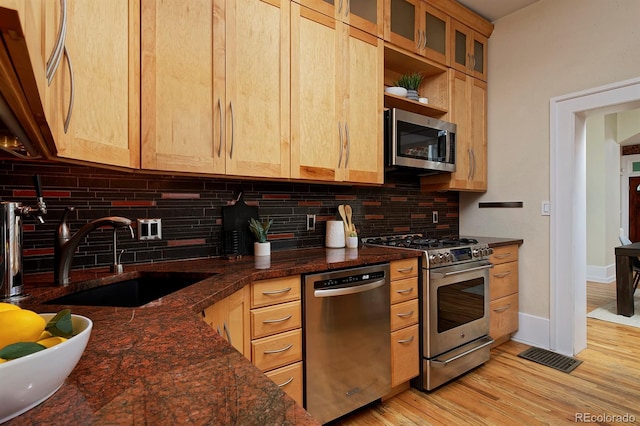 2527 W Dunkeld Pl, Denver, CO 80211 - kitchen with appliances with stainless steel finishes, decorative backsplash, light brown cabinets, and light wood-style flooring